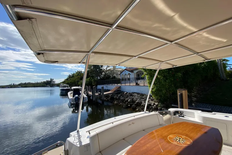  Yacht Photos Pics 2012 Sea Ray 610 Sundancer yacht docked by a serene waterfront.