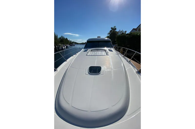  Yacht Photos Pics 2012 Sea Ray 610 Sundancer yacht on a sunny day, docked by a canal.