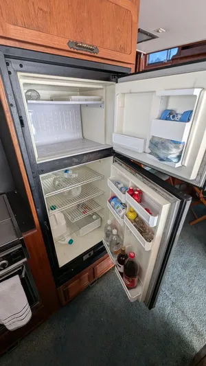 Guadalupe Yacht Photos Pics Open refrigerator inside 1989 Ditmar & Donaldson Custom Cruiser, showing stocked shelves and freezer.