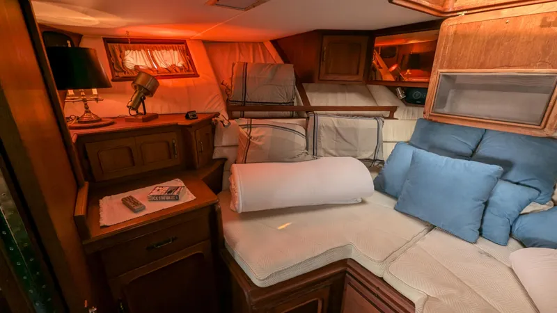 Guadalupe Yacht Photos Pics Cozy cabin interior of 1989 Ditmar & Donaldson Custom Cruiser with wood furnishings and cushions.