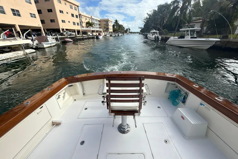 Sweet Melissa Yacht Photos Pics 1992 Ocean Yachts 48 Super Sport boat cruising through a canal with docked boats.