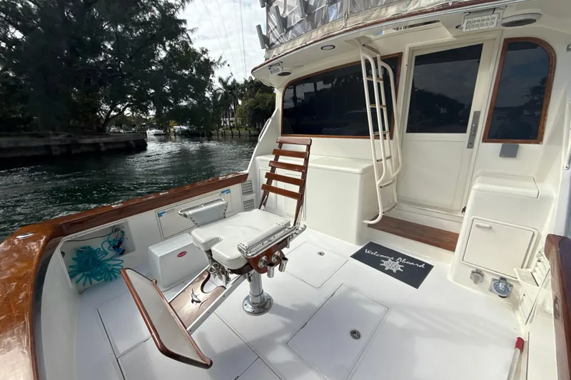 Sweet Melissa Yacht Photos Pics 1992 Ocean Yachts 48 Super Sport fishing deck with chair, docked by waterway.