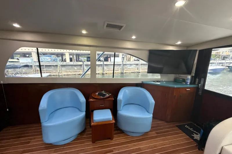 Sweet Melissa Yacht Photos Pics Interior of 1992 Ocean Yachts 48 Super Sport with blue chairs and a mounted TV.