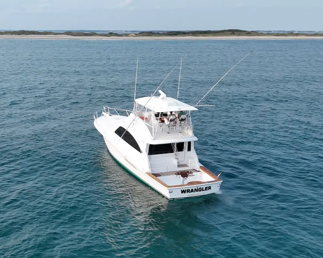 Wrangler Yacht Photos Pics 2008 Ocean Yachts 54 Super Sport cruising on open water, near a distant shoreline.