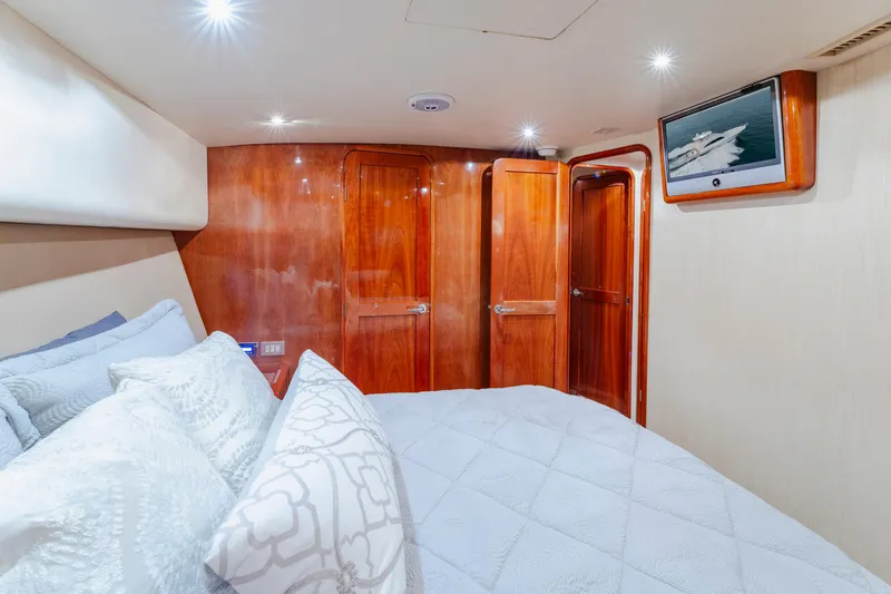 Wrangler Yacht Photos Pics Luxurious bedroom interior of 2008 Ocean Yachts 54 Super Sport with wood paneling and TV.
