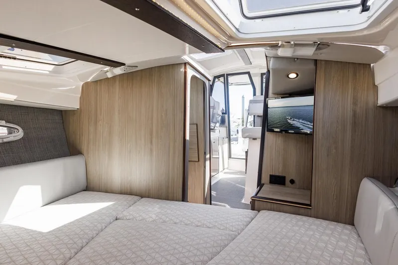  Yacht Photos Pics Luxurious interior of 2025 Solara S-250 Coupe with modern wood paneling and cozy bedding.