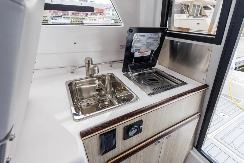  Yacht Photos Pics 2025 Solara S-250 Coupe interior kitchenette with sink and stove.