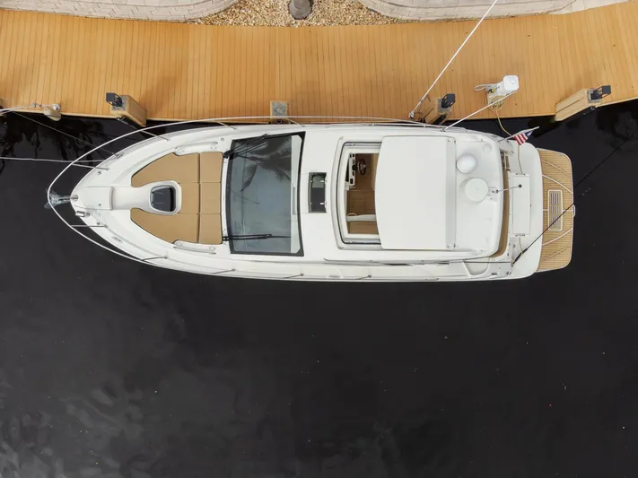  Yacht Photos Pics Aerial view of 2019 Sea Ray Sundancer 350 Coupe docked at a wooden pier.