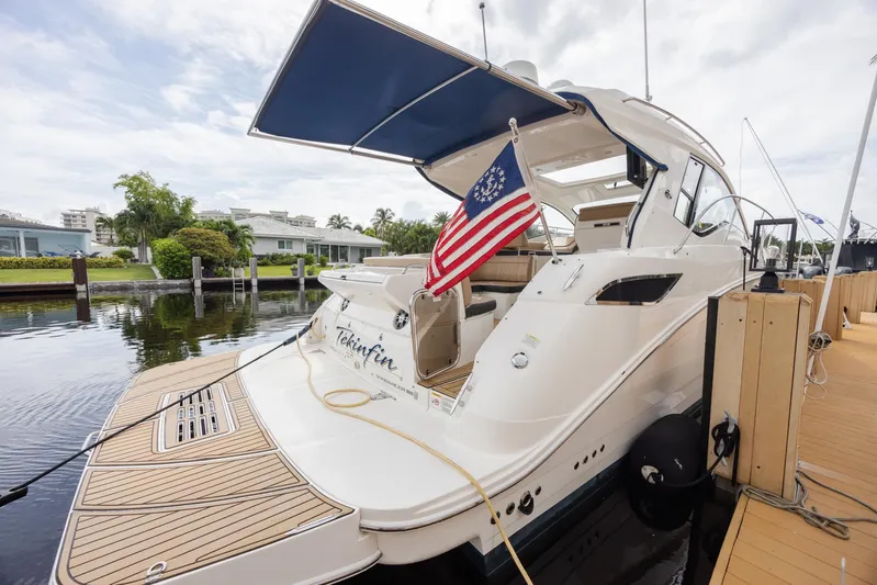  Yacht Photos Pics 2019 Sea Ray Sundancer 350 Coupe docked with American flag, featuring sleek design and spacious deck.