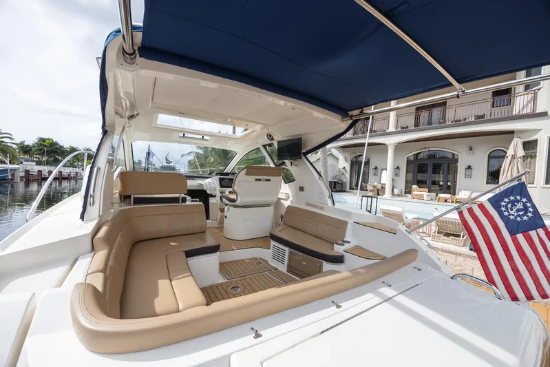  Yacht Photos Pics 2019 Sea Ray Sundancer 350 Coupe with luxurious seating and canopy, docked near waterfront home.