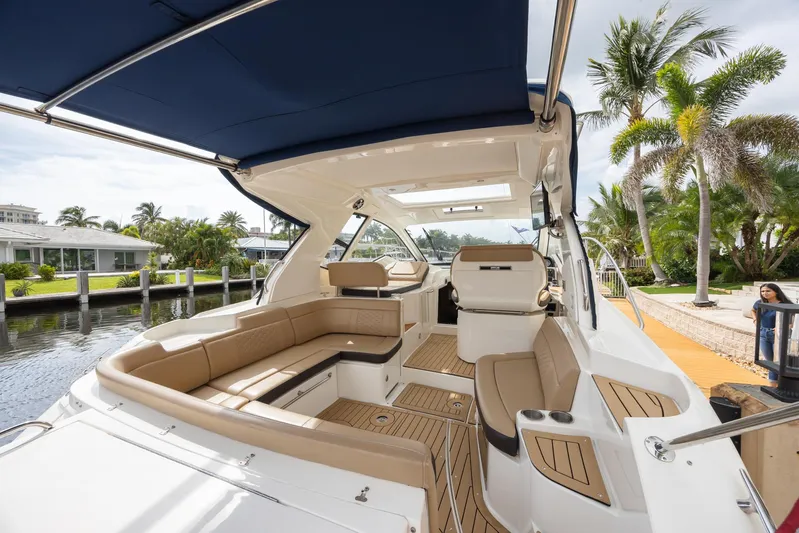  Yacht Photos Pics 2019 Sea Ray Sundancer 350 Coupe interior with seating, docked near palm trees.
