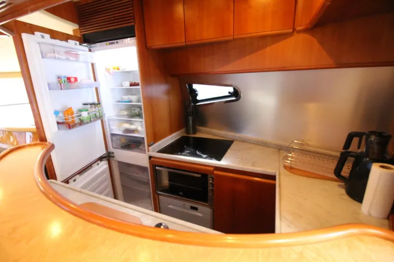  Yacht Photos Pics Compact kitchen in a 2007 Azimut 68 FLY yacht with open fridge and modern amenities.