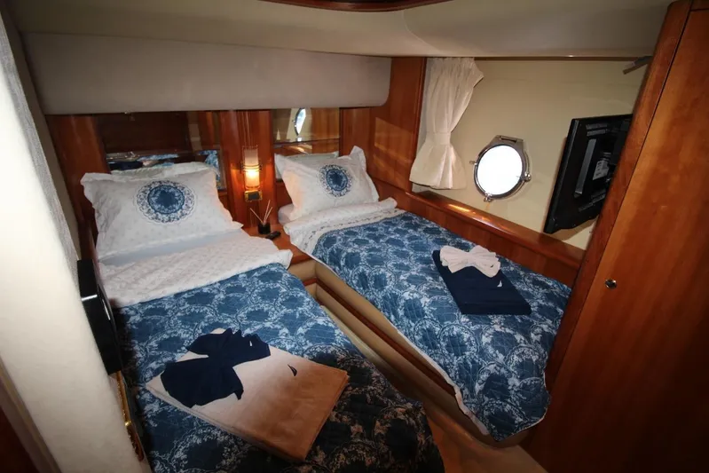  Yacht Photos Pics Twin cabin interior of 2007 Azimut 68 FLY yacht with blue bedding and porthole window.