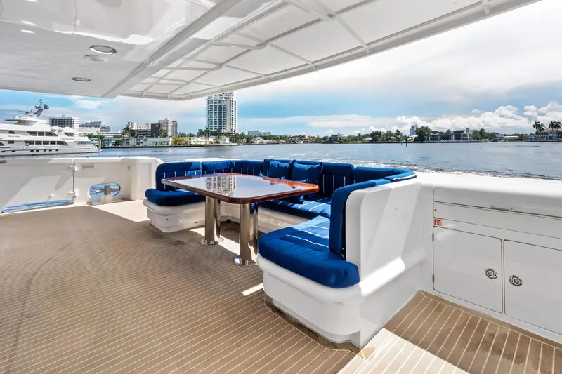 Pegasus Ix Yacht Photos Pics Luxury yacht deck with blue seating, wooden table, and scenic waterfront view. Sabre 92, 2004 model.