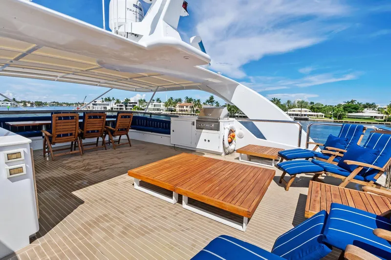 Pegasus Ix Yacht Photos Pics Luxurious 2004 Sabre 92 yacht deck with wooden furniture and blue cushioned seating.