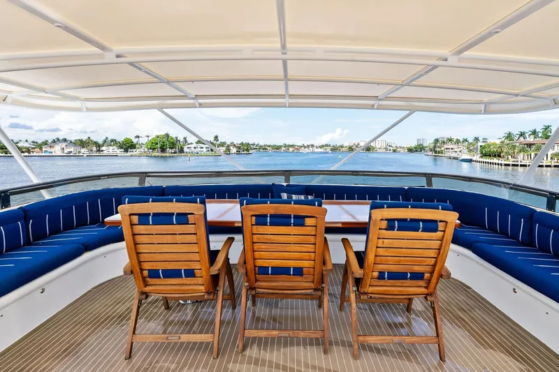 Pegasus Ix Yacht Photos Pics Yacht deck with wooden chairs, blue cushions, and waterfront view; Sabre 92, 2004 model.