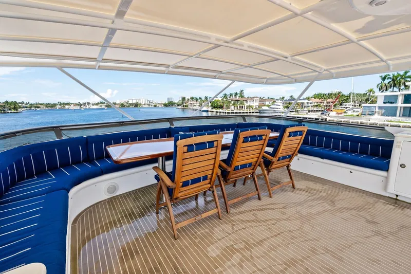 Pegasus Ix Yacht Photos Pics Luxurious 2004 Sabre 92 yacht deck with blue seating and wooden chairs, overlooking marina.