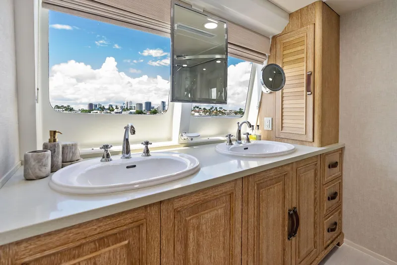 Pegasus Ix Yacht Photos Pics Luxurious yacht bathroom with dual sinks, wooden cabinetry, and ocean view through large window. Sabre 92, 2004.
