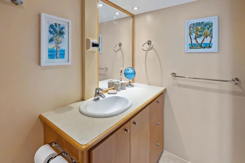 Pegasus Ix Yacht Photos Pics Modern bathroom vanity with mirror, palm tree artwork, and beige walls in a 2004 Sabre 92.