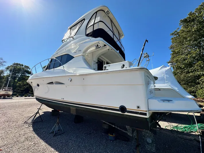 Cocktails & Dreams Yacht Photos Pics 2004 Silverton 38 Convertible yacht on dry dock under clear blue sky.
