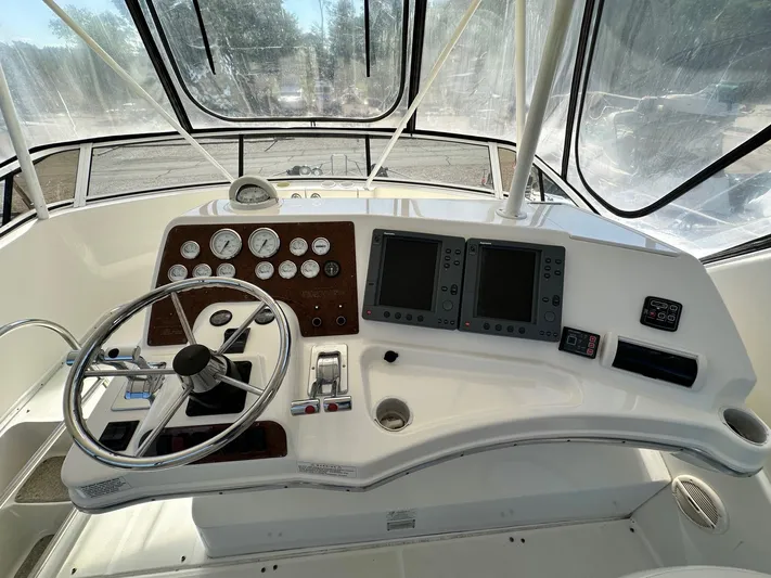 Cocktails & Dreams Yacht Photos Pics 2004 Silverton 38 Convertible helm with steering wheel, gauges, and navigation screens.