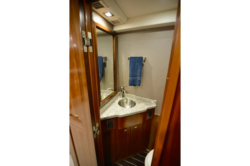 Slow Your Roll Yacht Photos Pics Luxurious bathroom in 2019 Viking 68 Convertible yacht with granite countertop and wooden cabinetry.
