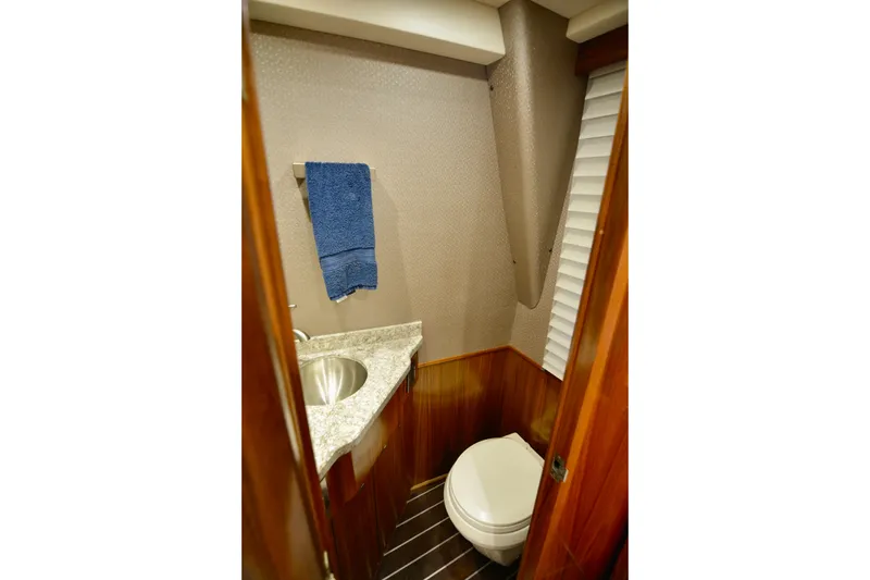 Slow Your Roll Yacht Photos Pics 2019 Viking 68 Convertible yacht bathroom with marble countertop and wooden accents.