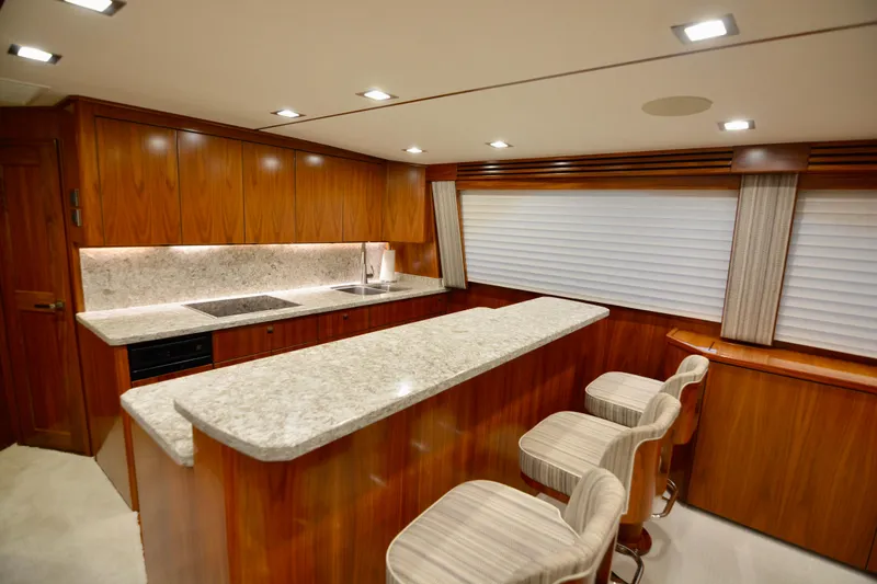Slow Your Roll Yacht Photos Pics Luxurious interior of 2019 Viking 68 Convertible yacht with modern kitchen and seating area.
