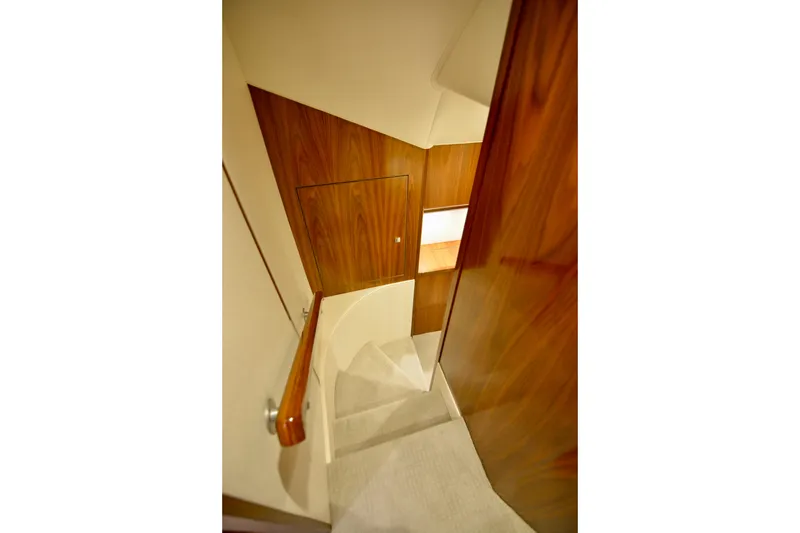 Slow Your Roll Yacht Photos Pics Interior staircase of 2019 Viking 68 Convertible yacht with wooden paneling.