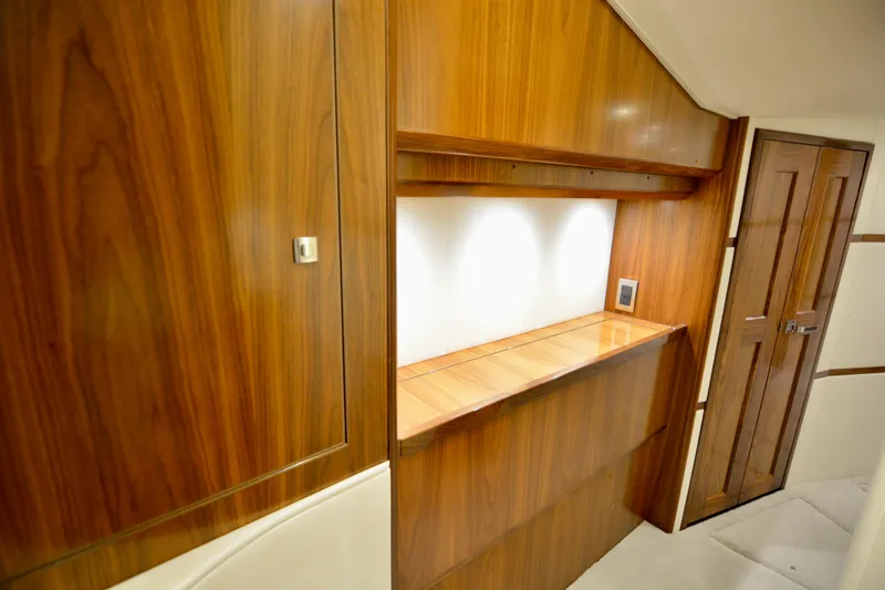 Slow Your Roll Yacht Photos Pics Luxurious wood interior of 2019 Viking 68 Convertible yacht, featuring elegant cabinetry and lighting.
