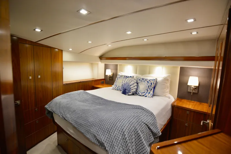 Slow Your Roll Yacht Photos Pics Luxurious bedroom interior of 2019 Viking 68 Convertible yacht with elegant wood finishes.