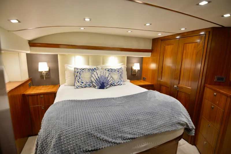 Slow Your Roll Yacht Photos Pics Luxurious bedroom interior of 2019 Viking 68 Convertible yacht with elegant wood finishes.