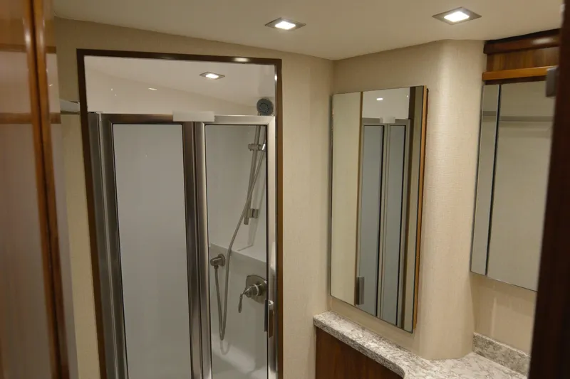 Slow Your Roll Yacht Photos Pics Luxurious bathroom interior of 2019 Viking 68 Convertible yacht with modern shower and mirrors.