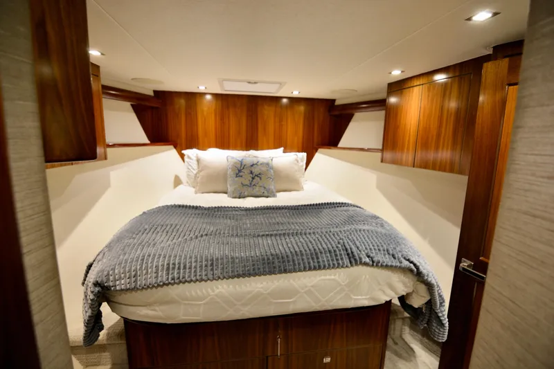 Slow Your Roll Yacht Photos Pics Luxurious bedroom interior of 2019 Viking 68 Convertible yacht with cozy bedding and wooden accents.