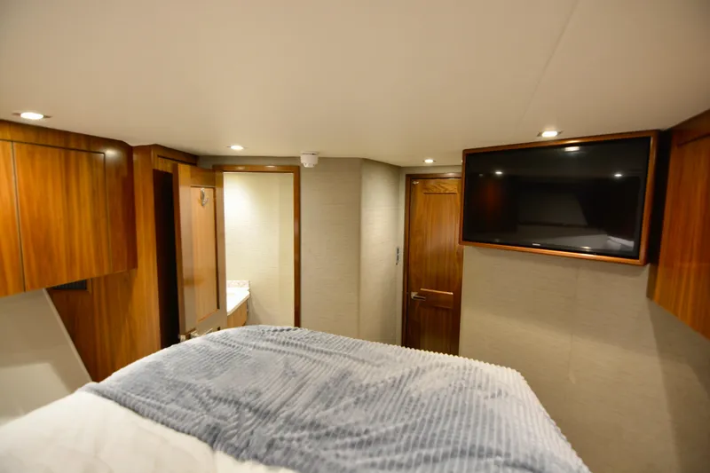 Slow Your Roll Yacht Photos Pics Luxurious cabin interior of 2019 Viking 68 Convertible yacht with TV and wood finishes.