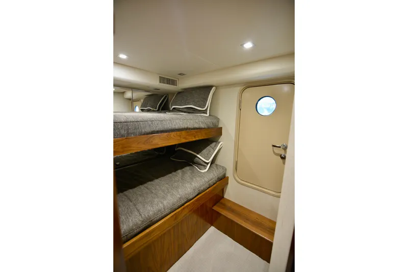 Slow Your Roll Yacht Photos Pics Interior of 2019 Viking 68 Convertible yacht with bunk beds and porthole door.