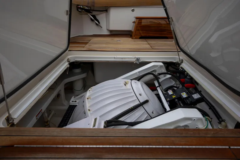 Slow Your Roll Yacht Photos Pics Engine compartment of 2019 Viking 68 Convertible yacht, showcasing mechanical components and wooden deck.