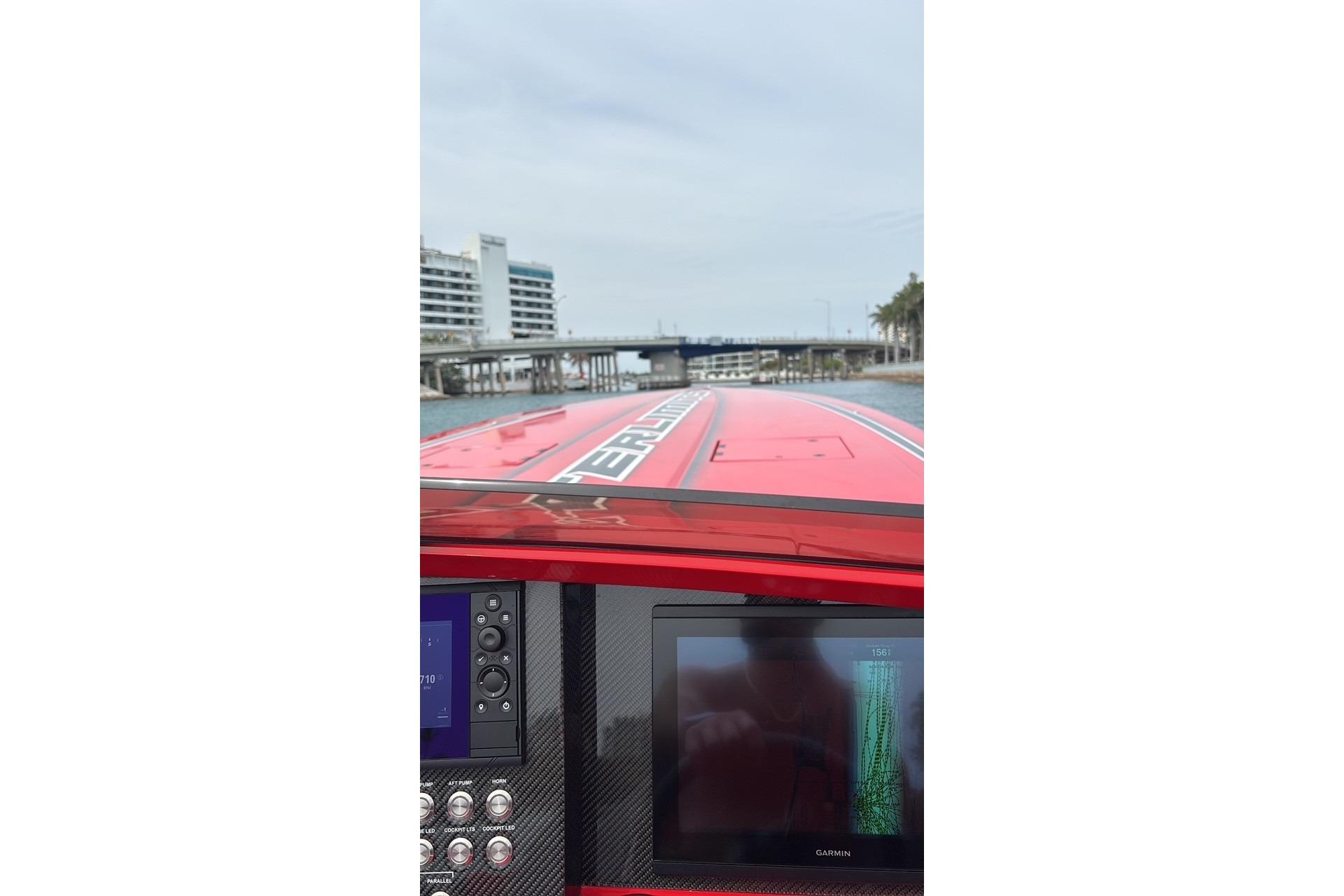 2022 Outerlimits SL41 boat dashboard with navigation screen, cruising near a bridge.