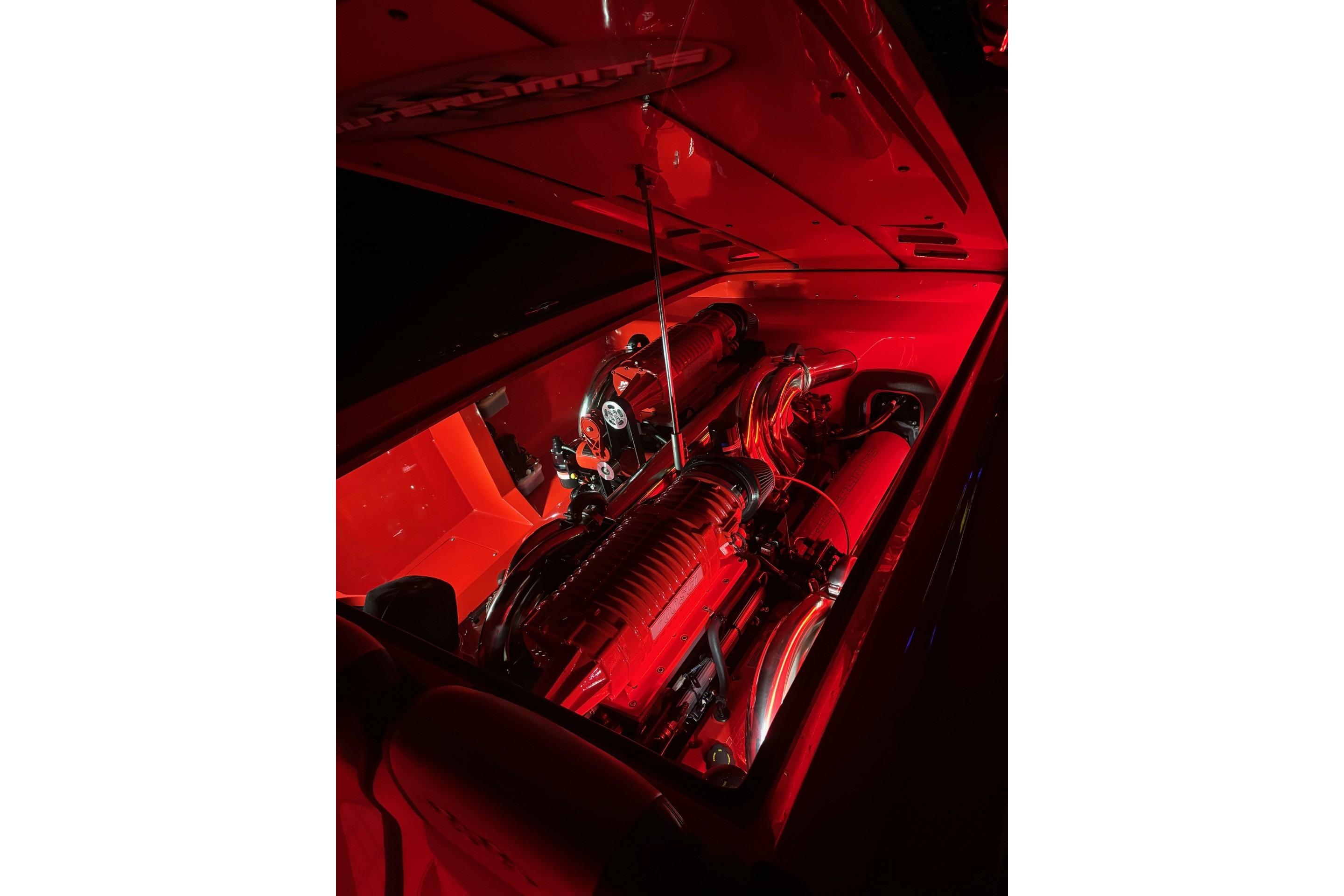Engine compartment of 2022 Outerlimits SL41 boat illuminated in red lighting.