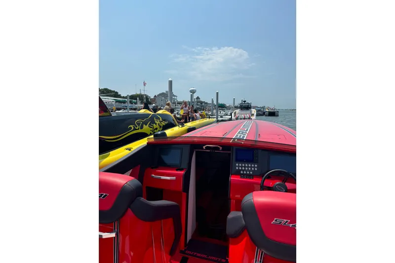  Yacht Photos Pics 2022 Outerlimits SL41 powerboat with vibrant red interior docked at a marina.
