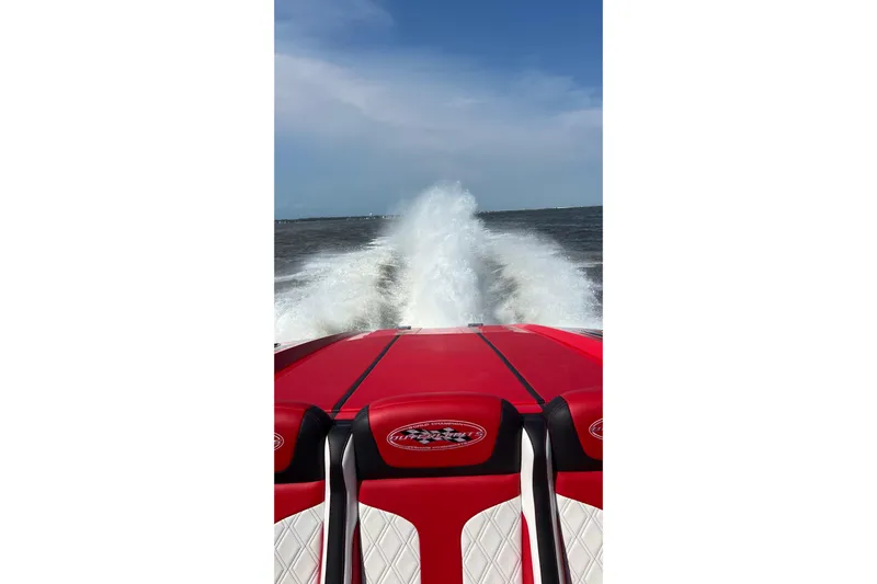  Yacht Photos Pics Red 2022 Outerlimits SL41 speedboat creating a wake on open water.