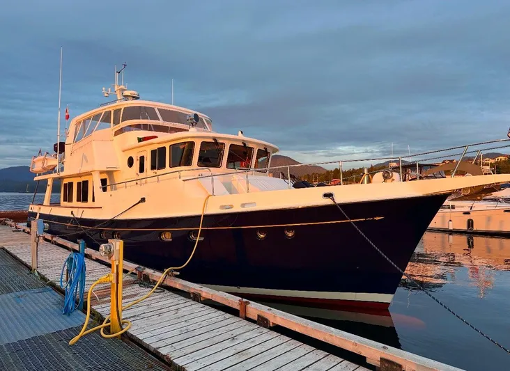 Blue Red Yacht Photos Pics 2006 Selene Pilothouse Ocean Trawler docked at sunset, reflecting on calm water.