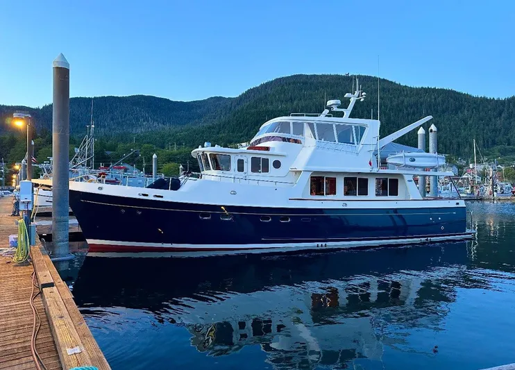 Blue Red Yacht Photos Pics 2006 Selene Pilothouse Ocean Trawler docked at a scenic marina with forested hills.