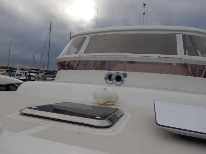 Blue Red Yacht Photos Pics 2006 Selene Pilothouse Ocean Trawler, docked under cloudy skies, showcasing its helm and deck.