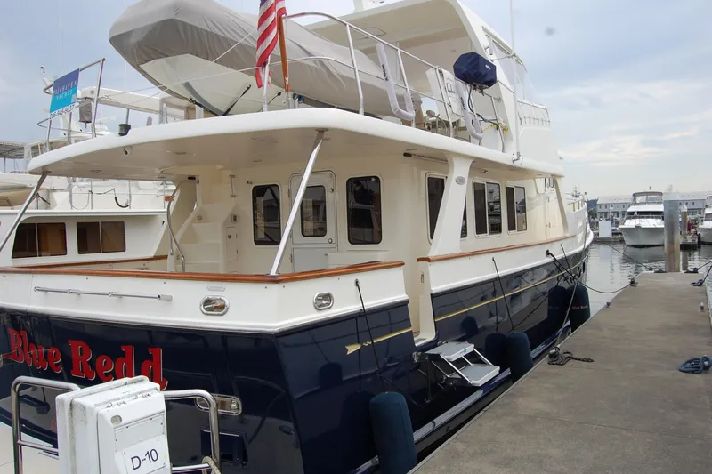 Blue Red Yacht Photos Pics 2006 Selene Pilothouse Ocean Trawler docked at marina, rear view with American flag.