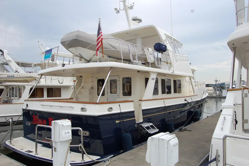 Blue Red Yacht Photos Pics 2006 Selene Pilothouse Ocean Trawler docked at marina, featuring spacious deck and American flag.
