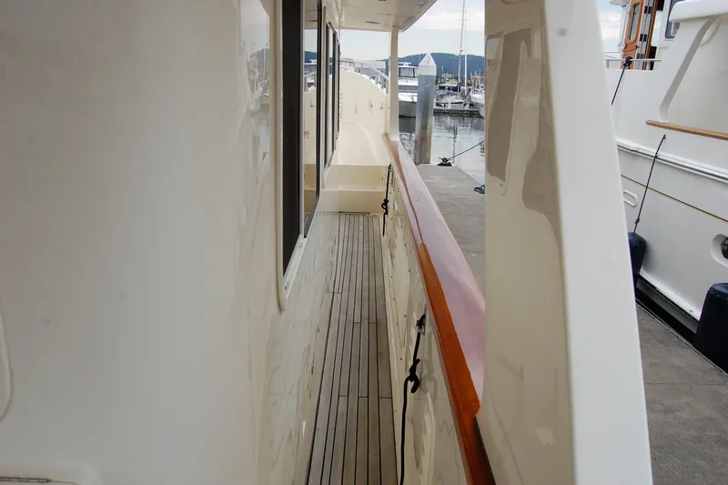 Blue Red Yacht Photos Pics 2006 Selene Pilothouse Ocean Trawler side deck with wooden railings, docked at marina.