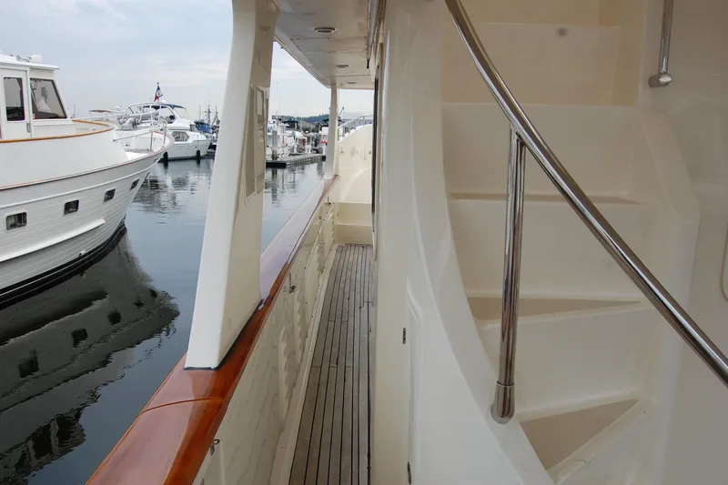Blue Red Yacht Photos Pics 2006 Selene Pilothouse Ocean Trawler deck with wooden flooring and staircase, docked at marina.