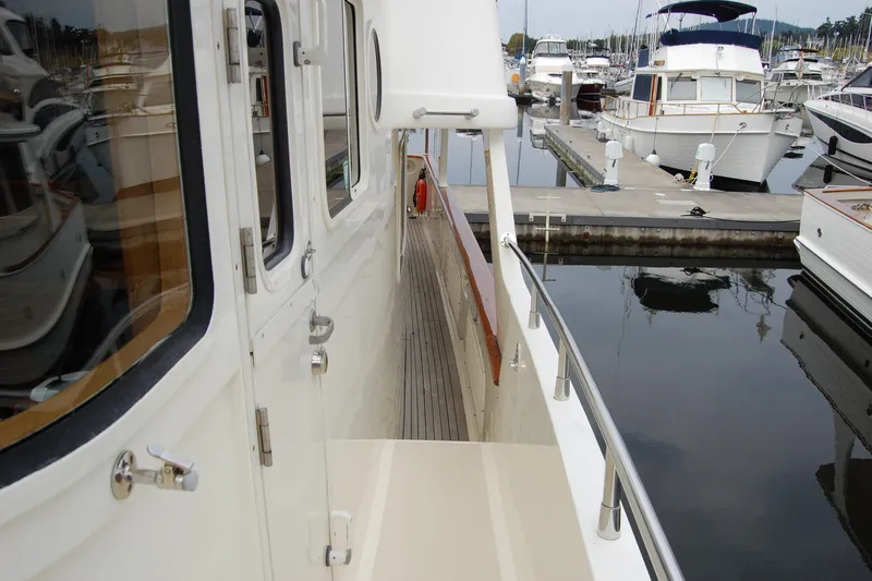 Blue Red Yacht Photos Pics 2006 Selene Pilothouse Ocean Trawler docked at marina, showcasing side deck and railing.
