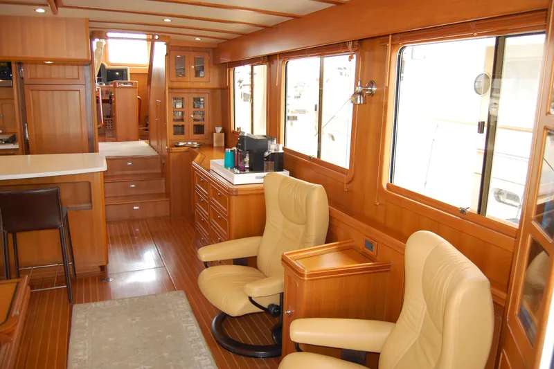 Blue Red Yacht Photos Pics Luxurious interior of 2006 Selene Pilothouse Ocean Trawler with leather chairs and wooden finishes.